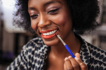 Amazing african american woman with curly hair smiling happily