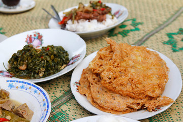 Straw mat with Indonesia traditional dishes and focus on crispy deep-fried eggs at Yogyakarta, Indonesia