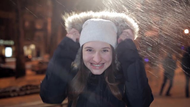 Young girl posing on a winter evening on camera. It is cold, winter