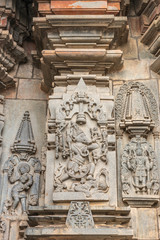 Fototapeta na wymiar Belur, Karnataka, India - November 2, 2013: Chennakeshava Temple. Gray wall stone panel sculpture of Lord Vishnu as his boar avatar. Smaller him again in classic pose, and a dancing girl, a Shilabalik