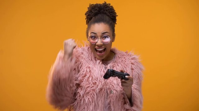 Excitable girl sincerely rejoicing her victory in video game, playing controller