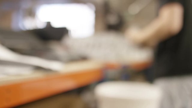 Blurred background of worker in a coffee warehouse prepping beans for packing