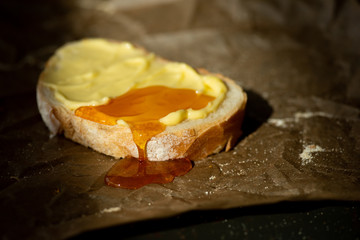 honey on buttered slice of bread on parchment