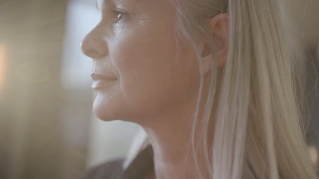 Close up of mature businesswoman standing in office and looking outside window. Senior business professional with grey hair looking away.
