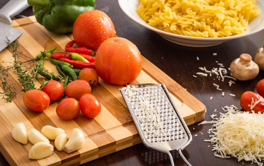 kitchen table  preparation with pasta and ingredients on chopping board.