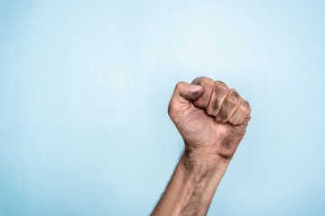 Male dirty fist hand on blue background