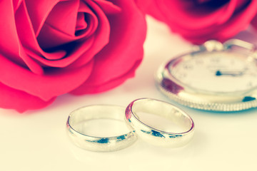 Obraz na płótnie Canvas Red rose and wedding ring on white