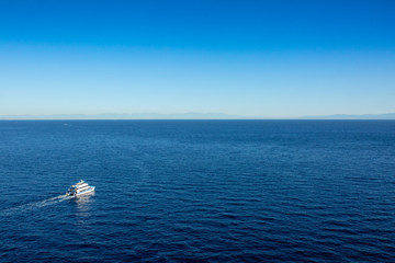 Ferry boat leaving Avalon harbor on Catalina Island in the early sunrise light.