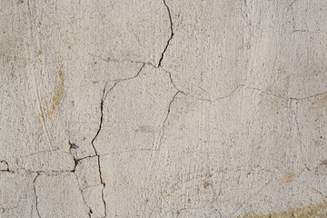 Concrete wall texture with cracked plaster. Weathered uneven rough surface. Perfect for background and grunge design.