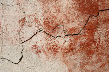 Obraz premium Concrete wall texture with cracked plaster. Weathered uneven rough surface. Red background. Perfect for grunge design.