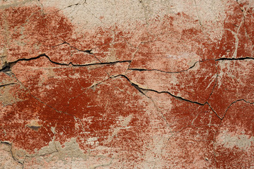 Concrete wall texture with cracked plaster. Weathered uneven rough surface. Red background. Perfect for grunge design.