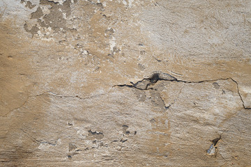 Concrete wall texture with cracked plaster. Weathered uneven rough surface. Perfect for background and grunge design.