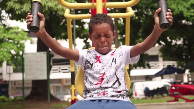 Boy At Park Working Out On A Seated Chest Press