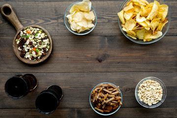 Fast food for TV watching. Snacks on desk.  Chips, nuts, rusks and soda on dark wooden background top view copy space