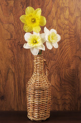Three white daffodils on a wood texture background.