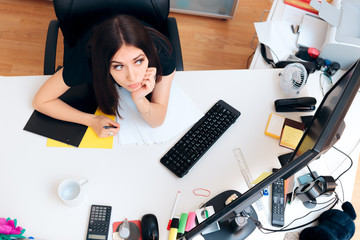 Tired Girl Sitting on Messy Desk Working Overtime 