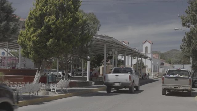 Trucks Driving Through Small Mexican Town