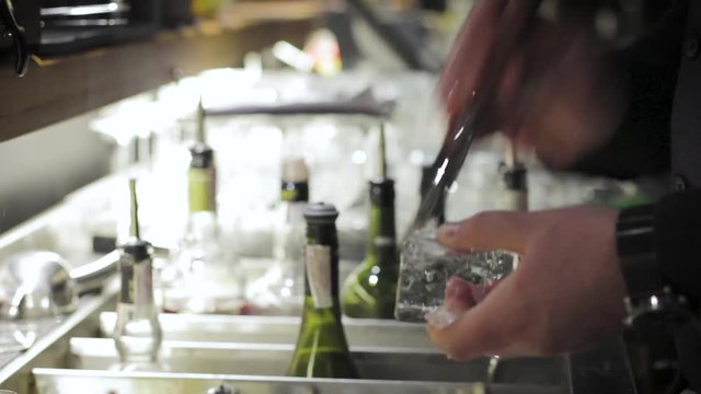 Bartender breaking ice with pick
