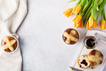 Hot cross buns, butter and jam for Easter breakfast and tulips