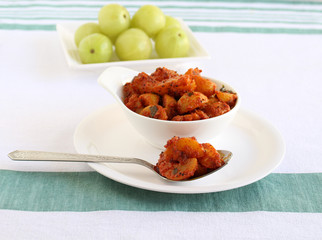 Indian gooseberry pickle on a spoon. This berry makes the pickle a healthy vegetarian side dish.