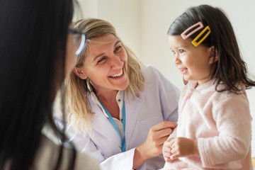 Pediatrician examining a little girl