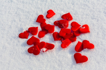 Many red hearts on glittering snow. Vilentine's day theme.