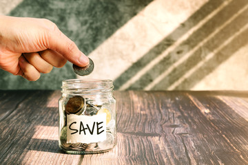 save money, woman put coins in glass jar for money saving financial concept