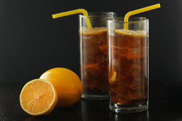 Glasses with cuba libre cocktail or cola with ice or cold tea with lemon
