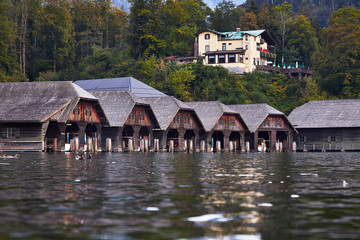 Fototapeta na wymiar Beautiful lake and wooden houses for ships on the water in Koenigssee in Germany