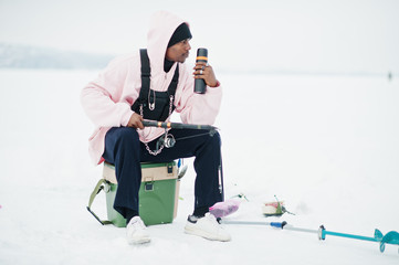 African american fisherman with fishing rod and thermos. Winter fishing.