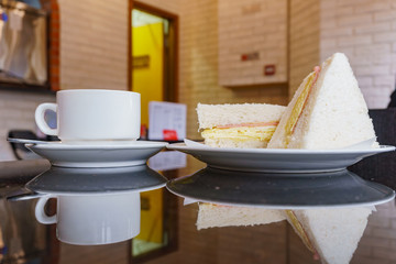Close up shot of a coffee, ham and egg sandwich with reflection