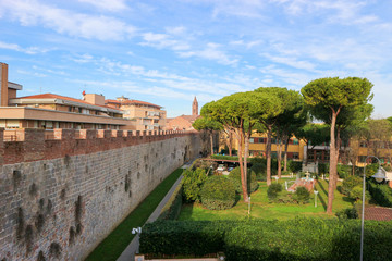 Fototapeta premium View of the Pisa ancient city wall with green trees and yard, Tuscany, Italy