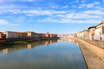 Fototapeta na wymiar Arno river and colorful houses around under the clear winter sky, Pisa, Tuscany, Italy