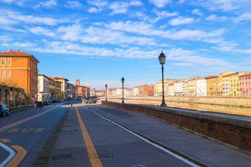 Arno river embankment in Pisa at winter sunny day, Tuscany, Italy