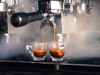 Two glasses of coffee cup and coffee machine makers selective focus.