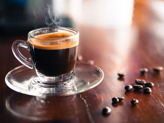 Closeup of Coffee cup and roasted coffee beans on wood table surface background with copy space selective focus