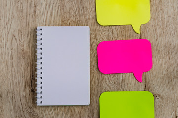 Business and office concept - blank notebook and stickers on wooden table. Minimal flat lay, top view.