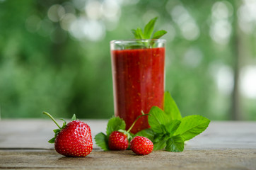  mint leaves, strawberries and strawberry cocktail smoothie on a wooden table