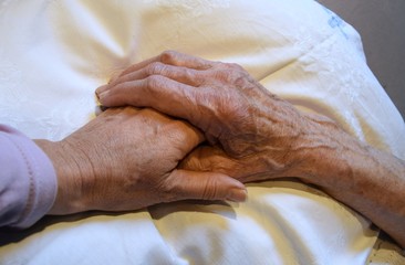 Fototapeta premium Hände eines sehr alten Mannes und einer alten Frau auf einer Decke
