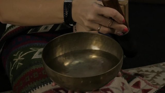 Woman operating with Tibetan singing bowls. yoga instructor conducts meditation. slow motion
