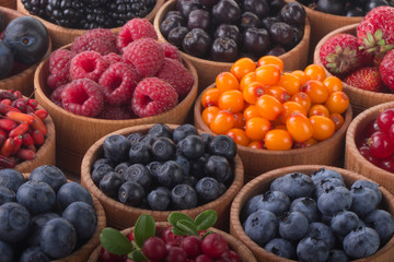 berries in wooden cups background