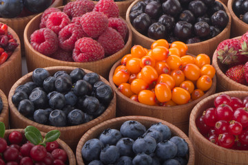 berries in wooden cups background