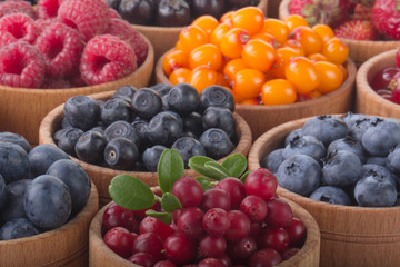 berries in wooden cups background