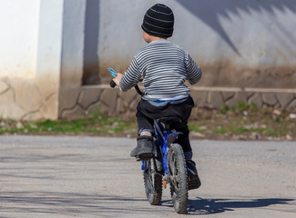 A boy rides a bike on the road