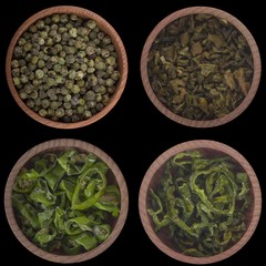 set of dried peppercorn in wooden cups isolated on black background