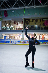 Figure skater woman at ice skating rink.