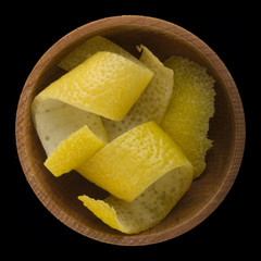 rind of lemon  in wooden cup isolated on black background. top view