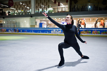 Fototapeta na wymiar Figure skater woman at ice skating rink.
