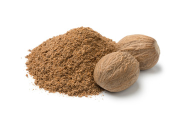 Heap of ground nutmeg and whole nutmeg seeds - obrazy, fototapety, plakaty