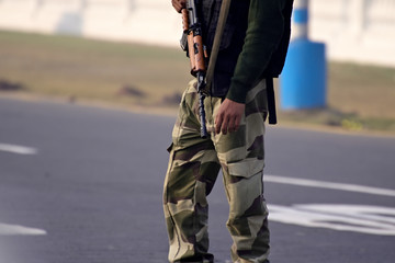 Security guard with rifle standing on outside to protect the area.